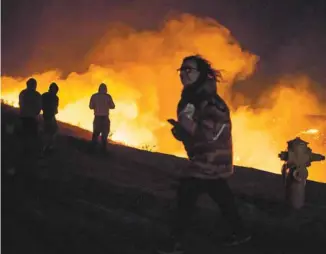  ?? KYLE GRILLOT AGENCE FRANCE-PRESSE ?? Des résidants de Los Angeles observant l’incendie dit de «Creek» qui a ravagé le quartier de Shadow Hills, en décembre dernier.