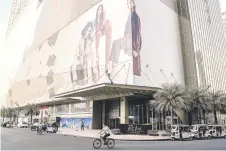  ?? ?? A man riding his bicycle past The Peak building with a large advertisin­g billboard in Phnom Penh.