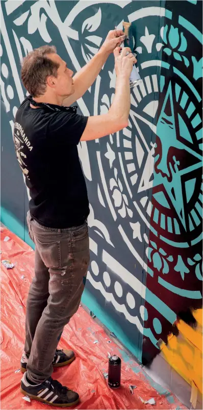  ??  ?? The American artist painting his first mural in the Middle East at Dubai’s Design District Opposite page, Shepard Fairey’s ‘Arab Woman’ (2020), and ‘Greater Than Fear’, far right