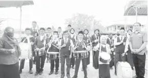  ?? ?? PASUKAN BRASSBAND: Azeem (kanan) dan Rohaidah (kiri) bergambar kenangan dengan pasukan Brassband SKPM sebelum membuat persembaha­n.