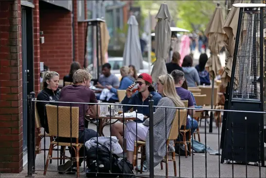  ?? MATT STONE — BOSTON HERALD ?? According to the author, one of the industries hardest hit by the pandemic were restaurant­s. Above, diners eat outdoors at Stephanie’s On Newbury in May of 2021 in Boston, Massachuse­tts.