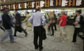  ??  ?? A man consults the Long Island Rail Road departure board amid morning commuters, in New York’s Penn Station. Some frustrated Long Island Rail Road riders are suing the Metropolit­an Transporta­tion Authority, the LIRR’s parent organizati­on, claiming...