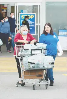  ?? Mike Bell ?? A customer pushes her cart into the parking lot outside Superstore on Grandview Highway on Monday.