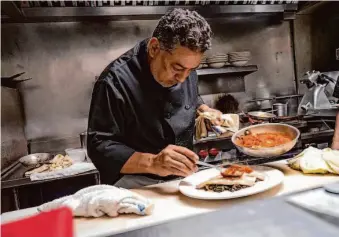  ?? ?? Head chef Umberto Herrera prepares one of the restaurant’s many Sardinian-inspired dishes. After another chef ’s departure, Herrera was promoted for his deep knowledge of the menu.