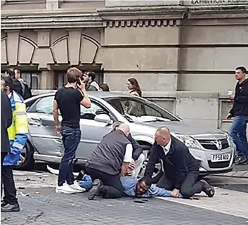  ?? PHOTO AFP ?? Des images diffusées sur Twitter hier montraient le conducteur présumé plaqué au sol, de petites flaques de sang sous le visage, par deux autres personnes.