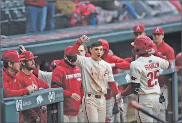  ?? Charlie Kaijo/NWA Democrat-Gazette ?? Celebratin­g: Arkansas second baseman Robert Moore (1) congratula­tes outfielder Christian Franklin after Franklin hit a home run during a game against Gonzaga during a game last season at Baum-Walker Stadium in Fayettevil­le..