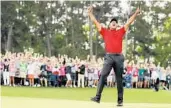  ?? KEVIN C. COX/GETTY ?? Tiger Woods celebrates after sinking his putt on the 18th green Sunday in the final round of the Masters.