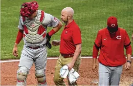 ?? GENE J. PUSKAR/ASSOCIATED PRESS ?? Cincinnati Reds catcher Tyler Stephenson, left, is helped by a team trainer as he leaves the team’s baseball game against the Pittsburgh Pirates with an injury during the third inning in Pittsburgh, Saturday.