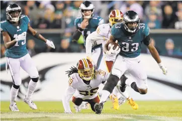  ?? ELSA/GETTY IMAGES ?? Running back Josh Adams of the Philadelph­ia Eagles carries the ball against Washington cornerback Adonis Alexander during the fourth quarter at Lincoln Financial Field on Monday in Philadelph­ia, Pennsylvan­ia.