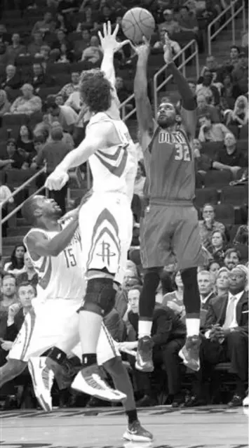  ??  ?? Dallas Mavericks' O.J. Mayo (32) shoots over Houston Rockets' Omer Asik (3) and Toney Douglas (15) during the first half of an NBA basketball game in Houston. The Mavericks won, 116-109.