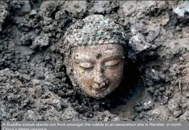  ??  ?? A Buddha statue stands out from amongst the rubble at an excavation site in Handan, in north China’s Hebei province
