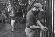  ?? JOSE M. OSORIO/CHICAGO TRIBUNE ?? Harry Sullivan, a guest enthusiast, opens a gate as Lincoln Park Zoo reopens to members.