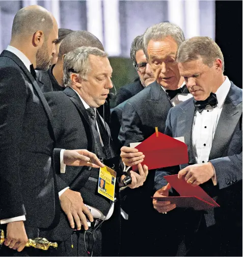  ??  ?? Brian Cullinan, right, holds the ‘best picture’ envelope he had handed to Warren Beatty as the actor looks over his shoulder. Mr Cullinan was yesterday said to feel ‘horrible’