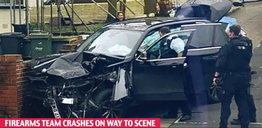  ??  ?? Smash: Officers stand by the crumpled wreck of unmarked police BMW after it hit wall in Streatham Common yesterday FIREARMS TEAM CRASHES ON WAY TO SCENE