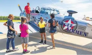  ??  ?? Mya Coley, from left, Narcissa, Brian Smith, Edwards and Ashanti Mallit stand in front of a North American T-6 Texan trainer aircraft, flown by the Tuskegee Airmen during World War II, on June 12.