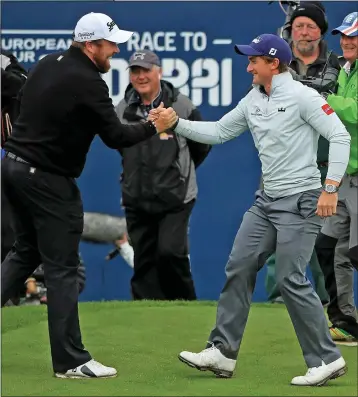  ??  ?? ABOVE: Paul Dunne is congratula­ted by Shane Lowry.
