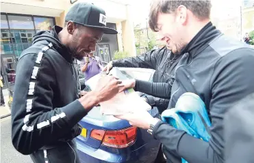  ?? RICARDO MAKYN/MULTIMEDIA EDITOR ?? Sprint king Usain Bolt is flocked by fans who want his autograph outside the Grange Tower Bridge Hotel in London, England. The Jamaican team will be staying there ahead of this week’s World Championsh­ips.
