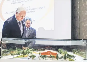  ??  ?? Najib (left) looking at a model scale of the lubricant factory Hyrax Oils Sdn Bhd at the plaque signing ceremony in Colombo, Sri Lanka. Also present is Minister of Internatio­nal Trade and Industry Datuk Seri Mustapa Mohamed. — Bernama photo