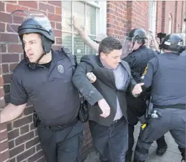  ?? Tasos Katopodis European Pressphoto Agency ?? JASON KESSLER, a “Unite the Right” march organizer, is whisked from City Hall in Charlottes­ville, Va., on Sunday as protesters shout “murderer” at him.