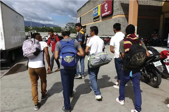  ?? FOTO: DELMER MARTINEZ/TT-AP ?? En grupp unga män i San Pedro Sula i Honduras är på väg mot USA. Bilden är från den 14 januari 2019.