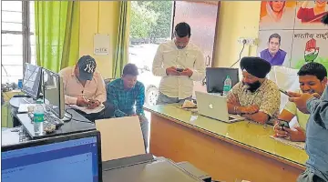  ?? ?? Congress social media team members work at party state headquarte­rs in Dehradun.