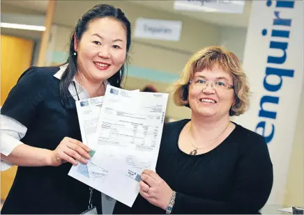  ?? Photo: MYTCHALL BRANSGROVE/
FAIRFAX NZ ?? New look: Timaru District Council and Environmen­t Canterbury rates will now be invoiced together in order to save costs. Pictured with the new-look invoice are Akemi Laplanche, left, and Tina Rogers.