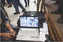  ??  ?? LOCAL GOVERNMENT workers use a laptop to project newly released video footage of the 12 rescued “Wild Boars” by Thai government public relations department during a press conference in Mae Sai in Chiang Rai district on July 11. The 12 boys rescued from...