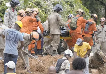  ?? LEO CORREA/AP ?? Brazilian firefighte­rs carry a body away Saturday after a mudslide devastated Boa Esperanca, or "Good Hope," shantytown in Niteroi, near Rio de Janeiro. Authoritie­s said 10 people were killed and 11 others injured when a boulder rolled on top of six houses.