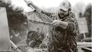  ?? Kirk Sides / Staff photograph­er ?? Hatchery technician­s like Hunter Adams will stock more than 330,000 rainbow trout by early March.