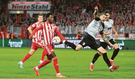  ?? Foto: Matthias Koch, dpa ?? Eine rasante Partie lieferten Union Berlin und der FC Augsburg. Hier kämpfen Sheraldo Becker (links) und FCA-Kapitän Jeffrey Gouweleeuw um den Ball. Der Angreifer hatte die Gastgeber nach einem Fehler von Rafal Gikiewicz in Führung gebracht.