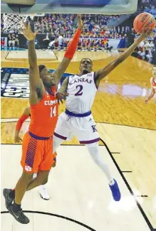  ?? THE ASSOCIATED PRESS ?? Kansas guard Lagerald Vick (2) heads to the basket as Clemson’s Elijah Thomas (14) defends during the first half of their Midwest Regional semifinal Friday night in Omaha, Neb.