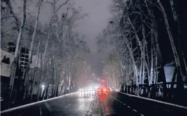  ?? EBRAHIM NOROOZI/AP ?? Cars drive on an unlit street during a blackout Wednesday in Tehran, Iran. Specialize­d computers that need huge amounts of electricit­y to mine Bitcoin have been blamed for recent rolling blackouts across the country.