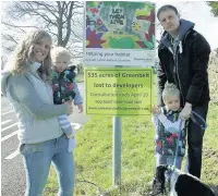  ??  ?? ●● Laura and David Furness with children Oscar and Lewis and dog Max with one of the signs posted up around Macclesfie­ld