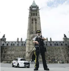  ?? SEAN KILPATRICK / THE CANADIAN PRESS ?? An RCMP officer stands watch on Parliament Hill after an incident during the Changing the Guard parade.