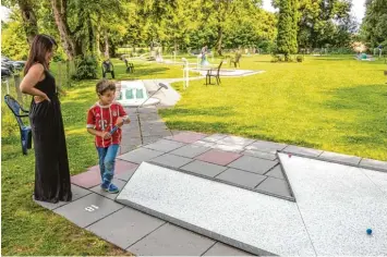  ?? Fotos: Michael Eichhammer ?? Gülay Schwertfir­m spielt zum ersten Mal Minigolf und knackt in Wellenburg gleich den Tagesrekor­d. Hier schaut sie Dennis beim Spielen zu.