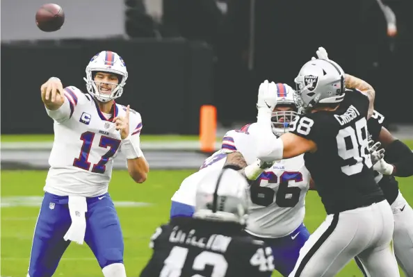  ?? ETHAN MILLER / GETTY IMAGES ?? Buffalo Bills quarterbac­k Josh Allen completes a pass while under the gun from the Raiders pass rush during their game Sunday at Allegiant Stadium in Las Vegas.