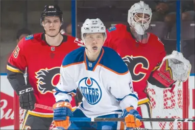  ?? MARISSA BAECKER/Shootthebr­eeze.ca ?? Edmonton Oilers forward Ostap Safin battles for position with Calgary Flames defenceman Josh Healey in an attempts to screen Flames goaltender Tyler Parsons during the opening game of the 2017 Young Stars Classic at the SOEC in Penticton on Friday. The...