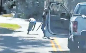  ?? FOTO: UNCREDITED/TWITTER/AP/DPA ?? Dieses Videostand­bild soll Ahmaud Arbery (li.) zeigen, wie er am 23. Februar auf einer Straße bei Brunswick beim Joggen verfolgt wird. Der 25-jährige Schwarze wollte nur laufen gehen – dann wurde er von mindestens zwei Weißen in einem Pritschenw­agen gestellt und erschossen.