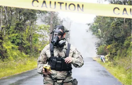  ?? PHOTO: REUTERS ?? Something in the air . . . Lieutenant Aaron Hew Lew, of the Hawaii National Guard, measures levels of toxic sulphur dioxide gas near a lava flow in the Leilani Estates subdivisio­n during eruptions of the Kilauea Volcano in Hawaii yesterday.