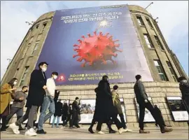  ?? A BANNER Ahn Young- j oon Associated Press ?? in front of City Hall in Seoul emphasizes enhanced social distancing, reminding passersby, “We have to stop before COVID- 19 stops everything.”