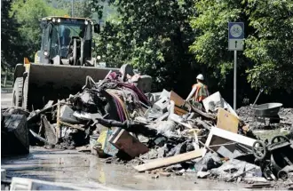  ?? Calgary Herald/files ?? Crews clean up in the community of Bowness on June 26, a few days after the flood. City infrastruc­ture damages amounted to $445 million from the disaster.