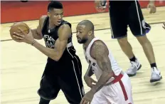  ?? JACK BOLAND/TORONTO SUN ?? Milwaukee Bucks’ Giannis Antetokoun­mpo keeps the ball away from Toronto Raptors P.J. Tucker during the third quarter of Game 1, in Toronto on Saturday.