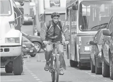  ?? TIMES COLONIST FILE ?? A cyclist wends his way through Victoria traffic. One letter-writer is optimistic about the increasing use of bicycles in the region, while another is skeptical about a bike-sharing service.