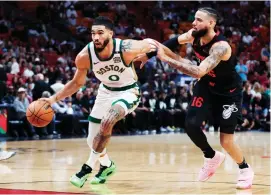  ?? — AFP photo ?? Jayson Tatum (left) drives against Caleb Martin of the Miami Heat during the first quarter of the game at Kaseya Centre in Miami, Florida.