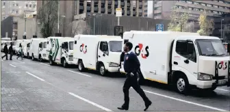  ?? PHOTO: REUTERS ?? A cash-in-transit worker walks past armoured vehicles parked on the street yesterday during a nationwide protest following a spate of deadly heists this year.