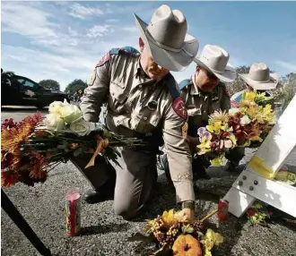  ?? Scott Olson/Getty Images/AFP ?? Policiais recolhem flores às vítimas na entrada de igreja batista em Sutherland Springs