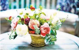  ?? QUENTIN BACON ?? A Cathy Graham arrangemen­t includes dahlias, garden roses and ranunculus­es plus fragrant rosemary, which signifies remembranc­e. It would make a nice Mother’s Day or get-well arrangemen­t.