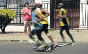  ??  ?? A resident of Riverlea, Soweto, offers runners water as they go through their paces during the annual Soweto Marathon yesterday.