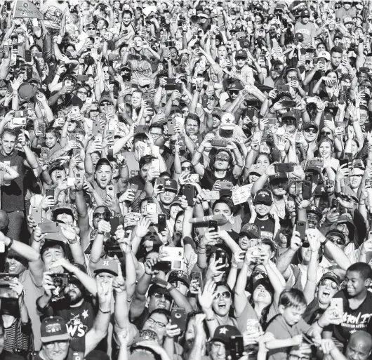  ?? Karen Warren / Staff file photo ?? Above: Thousands of Astros fans scream as World Series MVP George Springer, Carlos Correa, Mayor Sylvester Turner and Astros owner Jim Crane pass by during the parade downtown in November 2017.