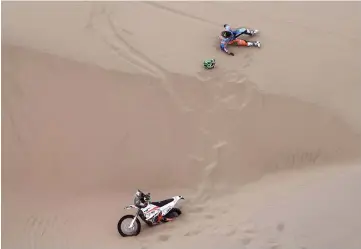  ?? — AFP photo ?? Brazilian biker Marcos Colvero lies on the sand after crashing during Stage 3 of the Dakar between San Juan de Marcona and Arequipa, Peru.